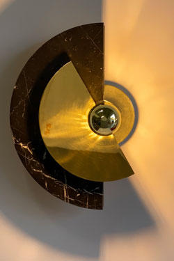 Round adjustable sconce in polished brass and black marble