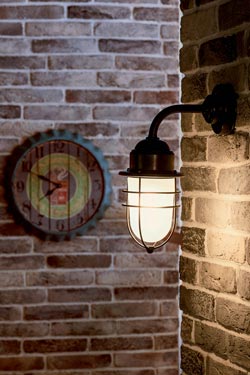 Storm exterior wall light in aged brass curved rod
